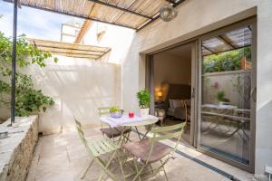 un patio con mesa y sillas. en Olydea le Château de la Redorte, en Laredorte