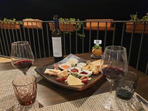 uma mesa com um prato de queijo e taças de vinho em Hotel Rural LAbadia de Sieste em Sieste