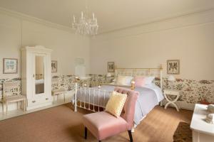 a bedroom with a bed and a chair and a chandelier at Healey Hall in Healey