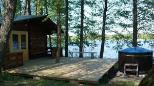 a cabin on a dock next to a lake at Agroturystyka nad jeziorem Gaładuś in Sejny