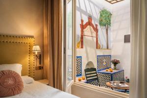 a hotel room with a bed and a window with a table at CH Apartments Boutique in Seville