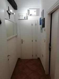 テルニにあるLe Pinelleの白いドア2つと鏡付きの廊下