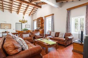 a living room with leather furniture and a tv at Villa Rafal Fort by Escape Home in Alaior