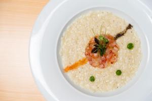 a white plate of rice with shrimp on it at Hotel dP Olbia - Sardinia in Olbia