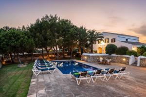 a swimming pool with lounge chairs and a house at Villa Rafal Fort by Escape Home in Alaior