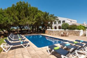 a swimming pool with lounge chairs and a house at Villa Rafal Fort by Escape Home in Alaior