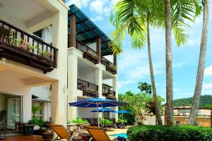 アオナンビーチにあるKrabi Apartment-SHA Extra Plusの椅子と傘とヤシの木があるホテル