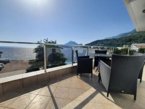 a balcony with chairs and a view of the water at Acacia apartmani Sutomore in Sutomore