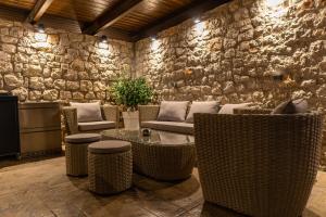 a lobby with wicker chairs and a stone wall at Adonis Villa in nature in Ixia