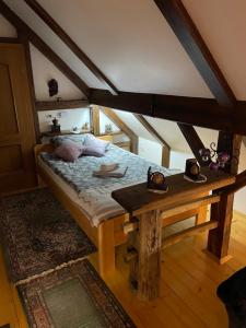 1 dormitorio con cama y mesa de madera en Hiša pod Rogatcem, en Luče