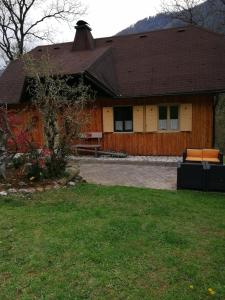 ein Haus mit einem Zaun und einer Couch im Hof in der Unterkunft Hiša pod Rogatcem in Luče