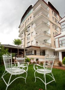 een groep stoelen in het gras voor een gebouw bij Bengisu suite apart in Trabzon
