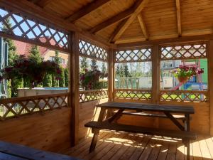 a wooden gazebo with a picnic table in it at Dom Goscinny Luna in Stegna