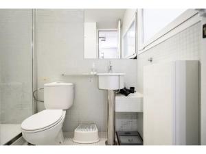 ein weißes Badezimmer mit Toilette und Waschbecken in der Unterkunft Espacioso Loft en Ponzano-Chamberí– Madrid in Madrid