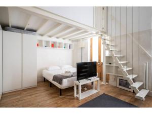 ein Schlafzimmer mit einem Bett und einer Treppe sowie einem TV in der Unterkunft Espacioso Loft en Ponzano-Chamberí– Madrid in Madrid