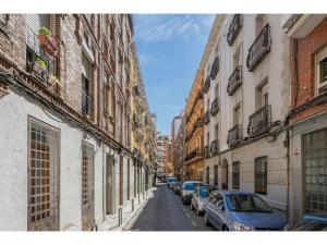 eine schmale Straße mit Autos auf den Seiten der Gebäude in der Unterkunft Espacioso Loft en Ponzano-Chamberí– Madrid in Madrid