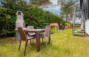 a table and chairs in a yard with a playground at Jarosławiec Pogodny Zakątek in Jarosławiec