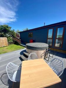 a patio with a table and chairs and a house at The Oak Lodge in Aberystwyth