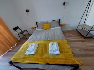 a bedroom with a bed with two towels on it at Wolley - Peniche GuestHouse 2 in Peniche