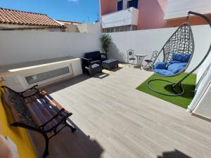 a patio with two chairs and a tv and avisor at Wolley - Peniche GuestHouse 2 in Peniche