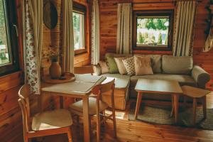 a living room with a couch and a table and chairs at HORBACZÓWKA in Czerwonki