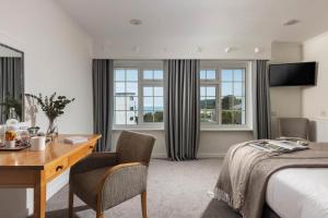 um quarto de hotel com uma secretária e uma cama em St Michaels Resort, Falmouth em Falmouth