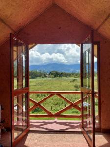 ein offenes Fenster mit Blick auf ein Feld in der Unterkunft Casa Hospedaje el Prado Eco turismo in Oxapampa