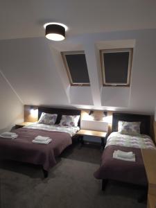 duas camas num quarto com duas janelas em Hotel Regina em Radom