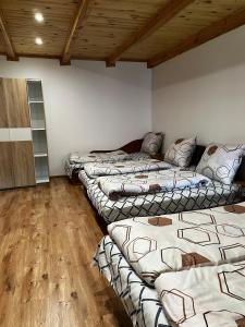 three beds in a room with wooden floors at Agroturystyka Nielisz Zamość - Kwatery przy Skansenie in Nielisz
