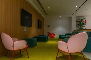 a waiting room with green chairs and pink chairs at The Boc Hostels - City in Palma de Mallorca