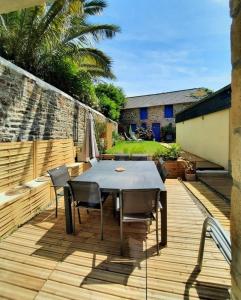 un patio con mesa y sillas en una terraza en LE COCON de MATIGNON Gîte 4 étoiles 5 kms mer, en Matignon