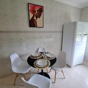 comedor con mesa, sillas y nevera en Sónia&Irene Apartments en Setúbal