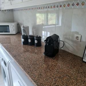 a kitchen counter with a toaster and three trash cans on it at Sónia&Irene Apartments in Setúbal