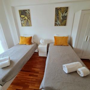 2 camas en una habitación con suelo de madera en Sónia&Irene Apartments en Setúbal
