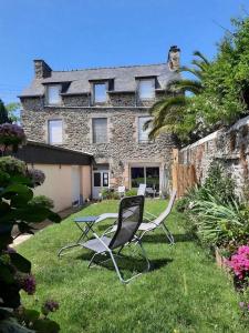 2 chaises et une table en face d'une maison dans l'établissement LE COCON de MATIGNON Gîte 4 étoiles 5 kms mer, à Matignon