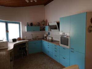 a kitchen with blue cabinets and a stove top oven at Anna vendégház in Keszthely