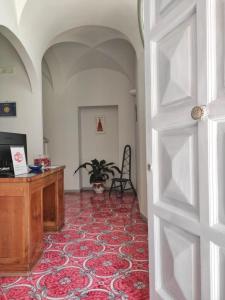 um quarto com uma secretária e uma porta com um tapete em R&D Rest and Dream Capri em Anacapri