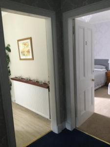 una puerta abierta a una habitación con dormitorio en Inverlochy Villas (Adults Only) en Fort William