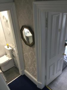 La salle de bains est pourvue d'un miroir, d'un lavabo et de toilettes. dans l'établissement Inverlochy Villas (Adults Only), à Fort William