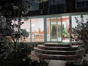 a house with glass doors and stairs in a yard at Residencial Playa Lisa in Boadilla del Monte