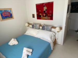 una camera da letto con un letto blu e asciugamani di Dal Notaio, Appartamento Con Terrazza a Marettimo