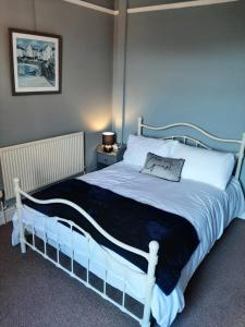 a bedroom with a white bed with a black blanket at Woldgate Retreat Bridlington in Bridlington