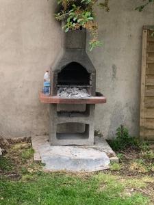 an outdoor oven with a bottle of water on it at Villa Tenjin Chambre 6 in Bondy