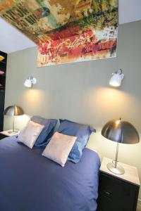 - une chambre avec un lit bleu et 2 oreillers dans l'établissement Le Grunge, T2 hypercentre chic et cosy, Wifi par SOVALFI, à Saint-Étienne