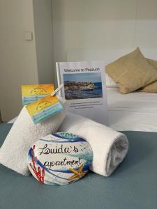 波佐利的住宿－Luida's Apartment，床上有标志的毛巾