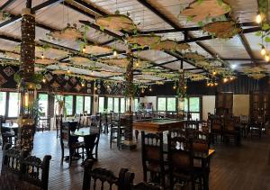 薩蘭托的住宿－Hotel Momotus Cocora，用餐室配有桌椅和带遮阳伞的天花板。