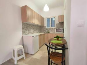 una piccola cucina con un piccolo tavolo e sedie di Panos Apartment Kanoni Corfu a Análipsis