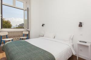 a bedroom with a bed and a large window at Lisbon Old Town Guest House in Lisbon