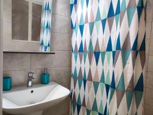 bagno con lavandino e tenda doccia di Panos Apartment Kanoni Corfu a Análipsis