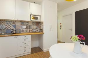 a kitchen with a white counter top and white cabinets at Lisbon Old Town Guest House in Lisbon